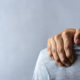 Man squeezing shoulder pain while looking for a great chiropractor in Lawrenceville.