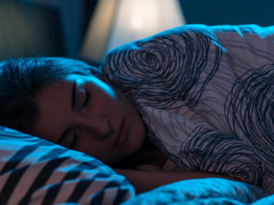 Woman sleeping in blue background light