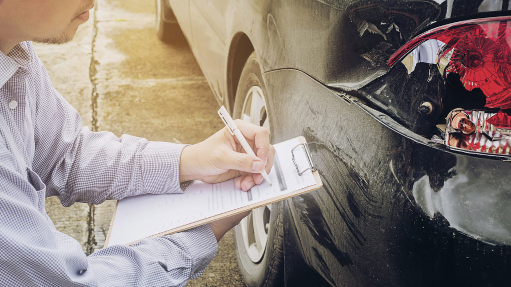 Insurance adjuster writing up a vehicle damage claim.